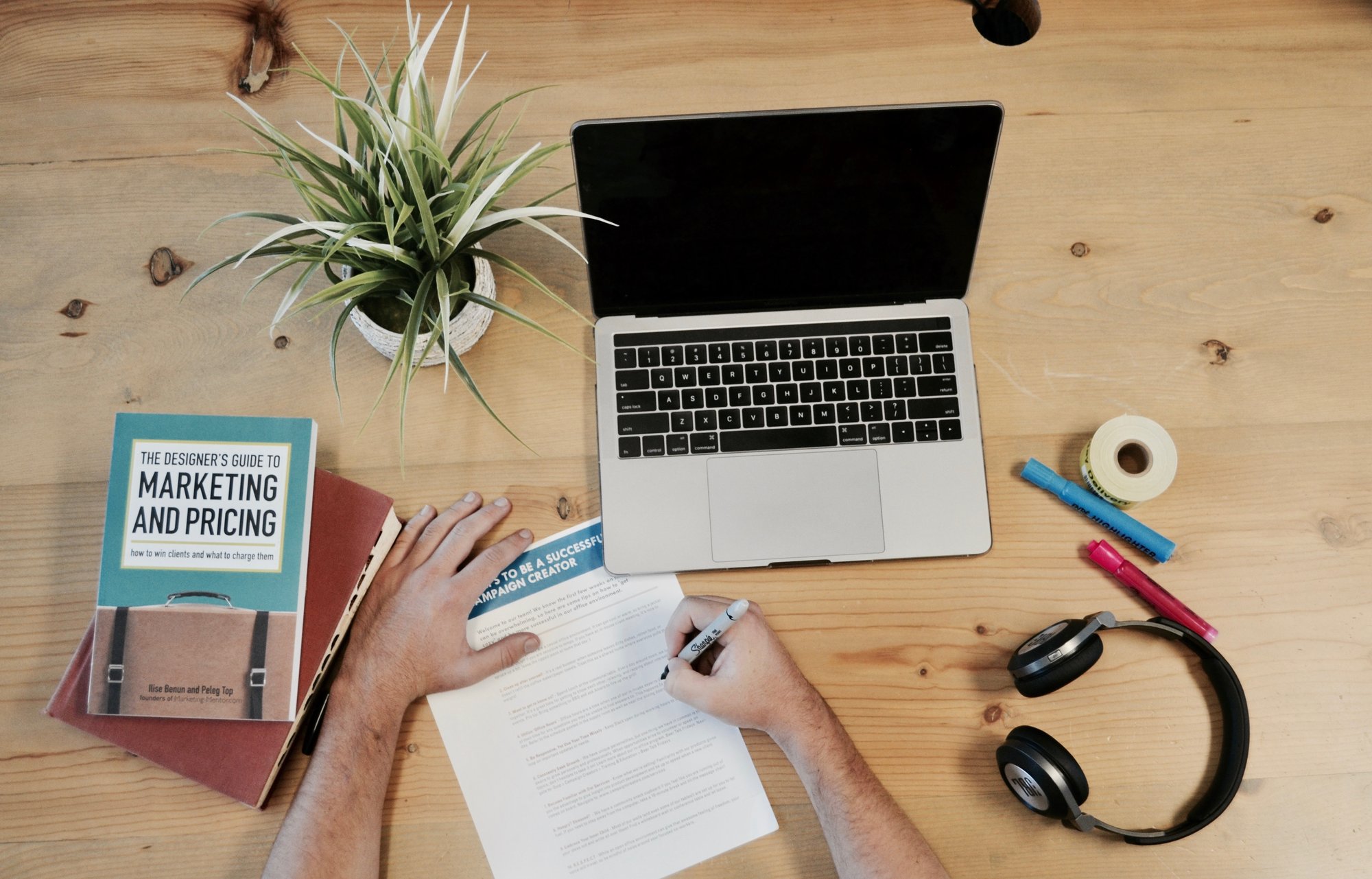 desk with laptop, books, and pens