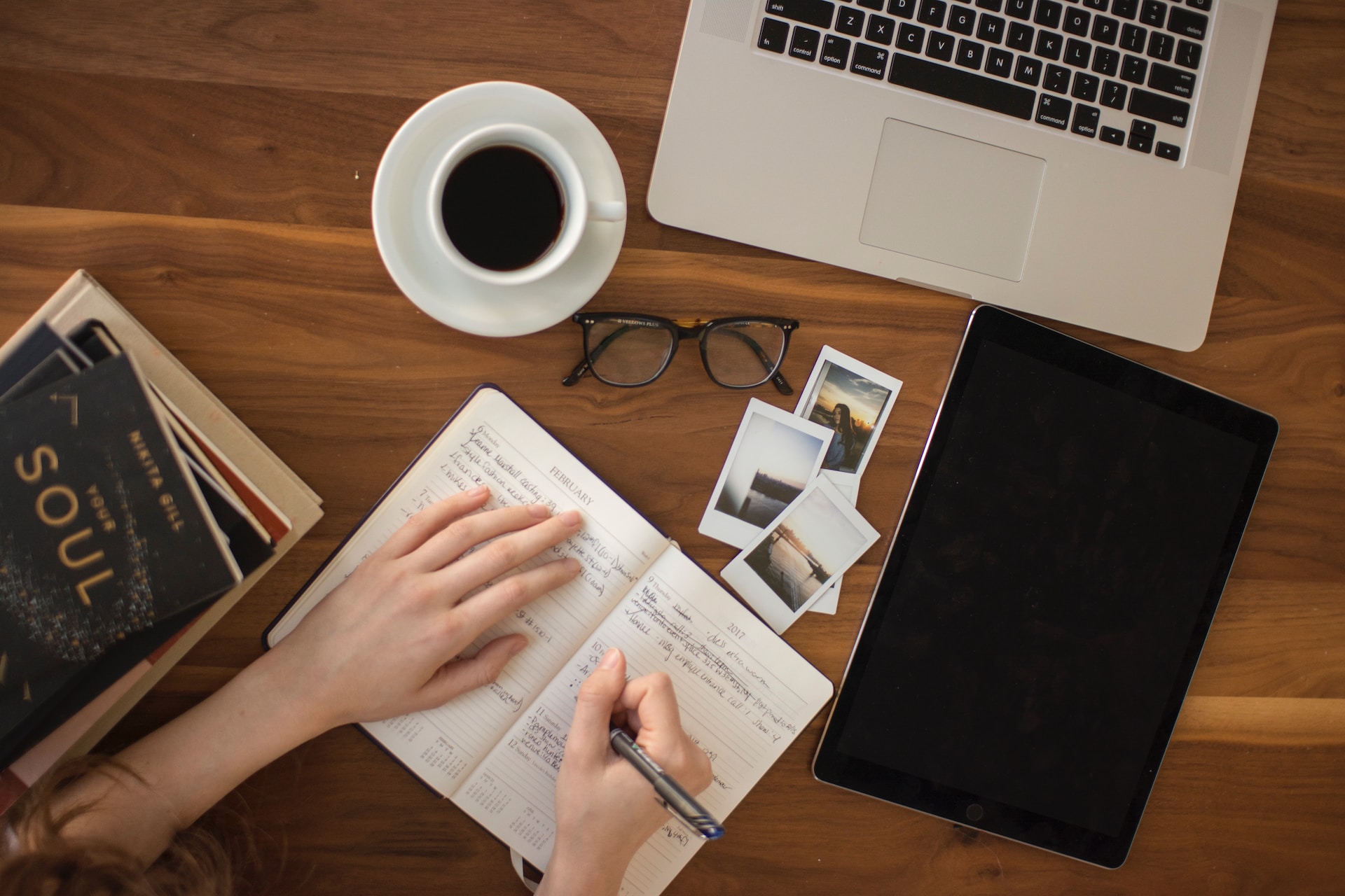 person-holding-ballpoint-pen-writing-on-notebook